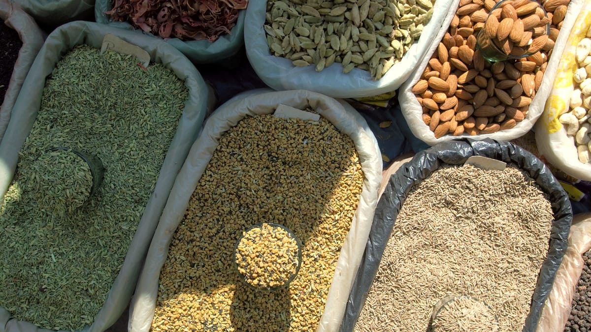 Offene Säcke mit getrockneten Kräutern, Samen und Nüssen an einem Marktstand