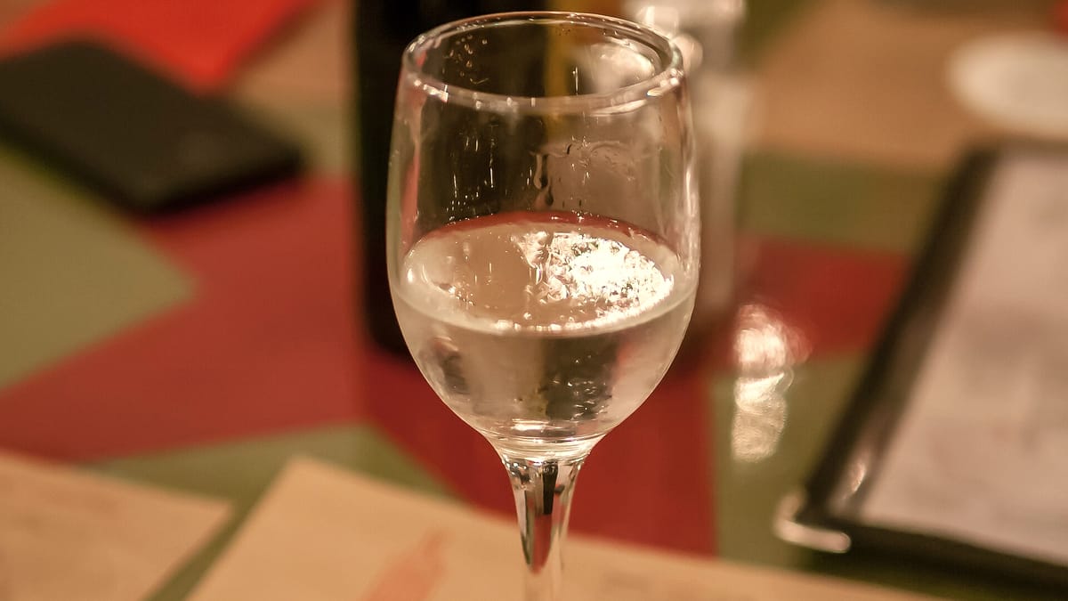 Ein Glas klarer albanischer Raki auf einem gedeckten Tisch